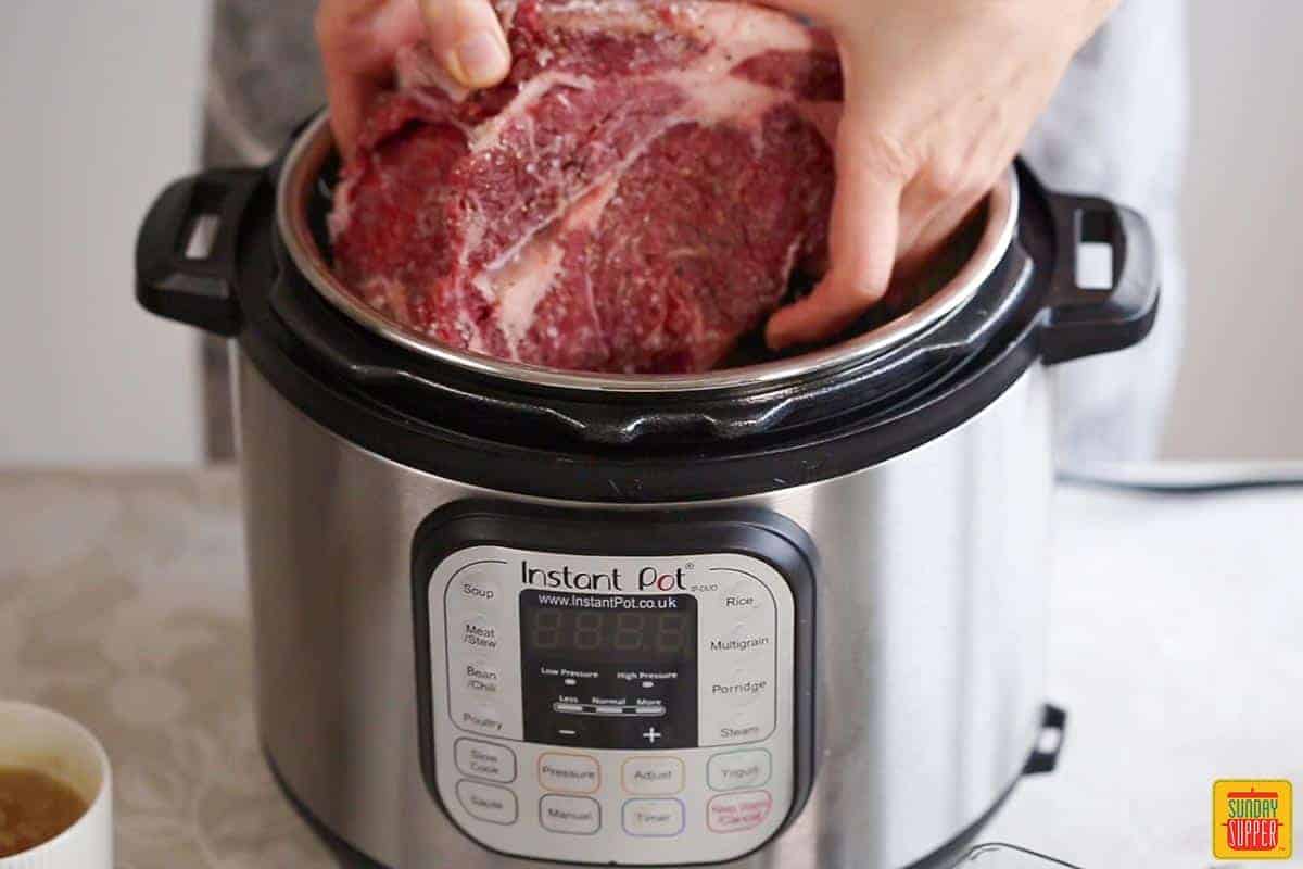 adding a boneless rib roast to the instant pot after placing the trivet