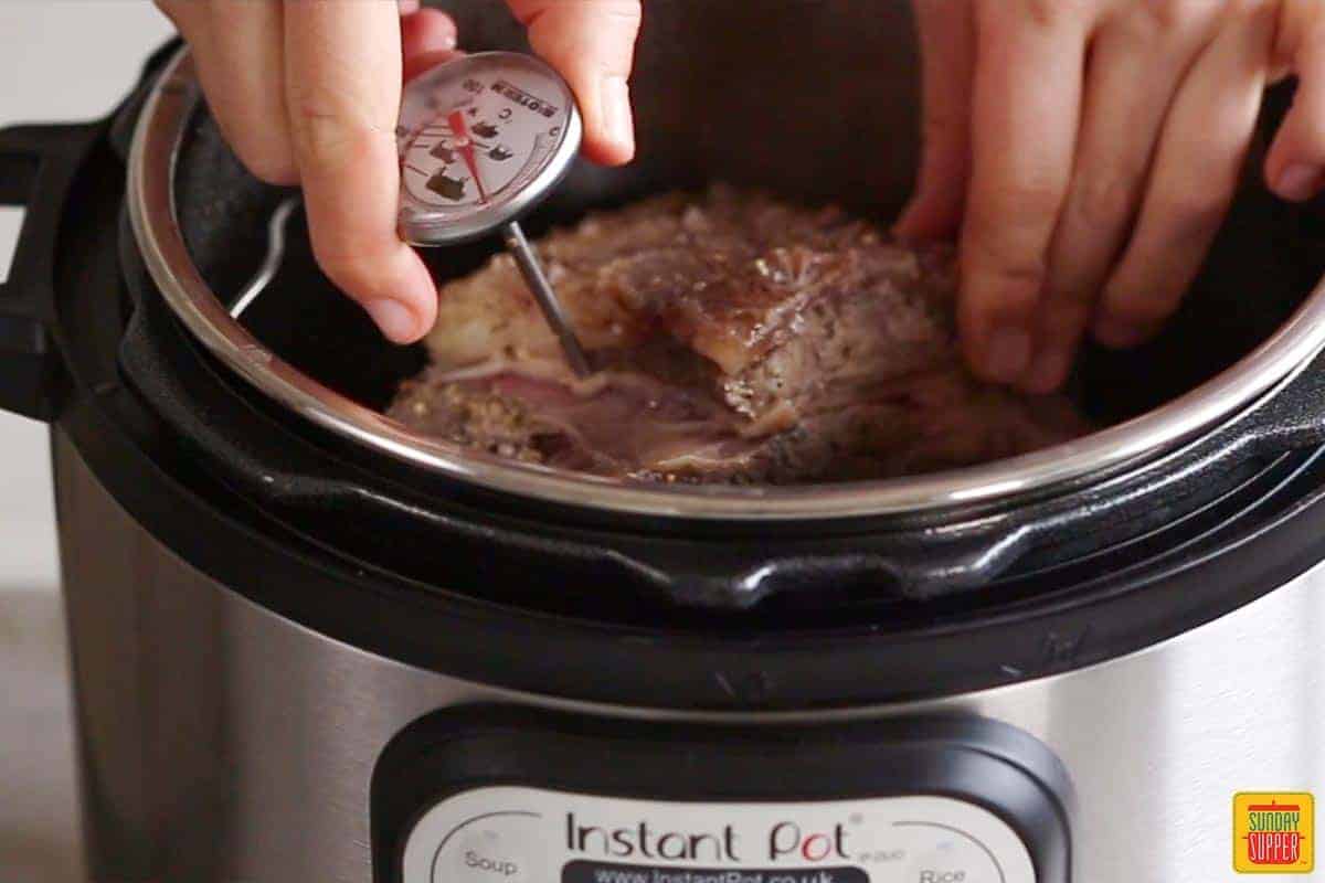 checking the temperature of a boneless rib roast in the instant pot