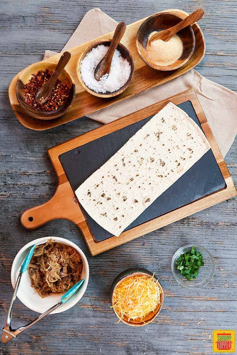Ingredients to make pulled pork pizza flatbread recipe on table