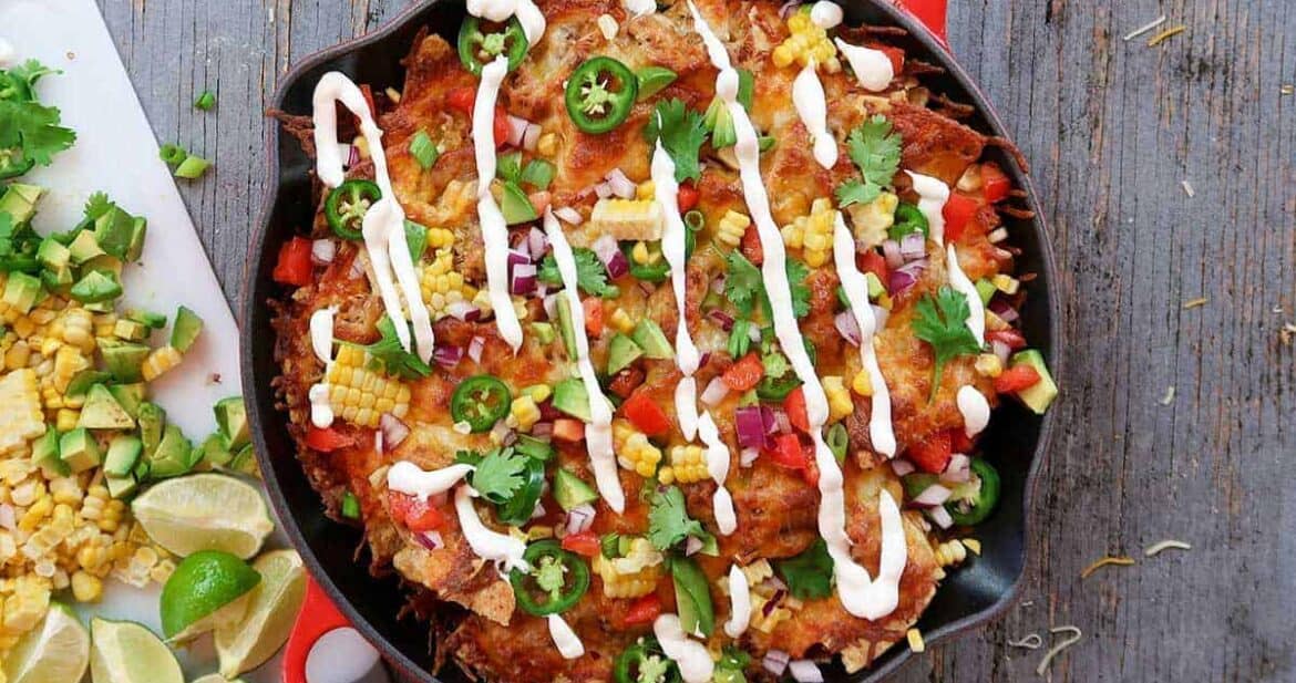 Sour cream drizzled over baked nachos