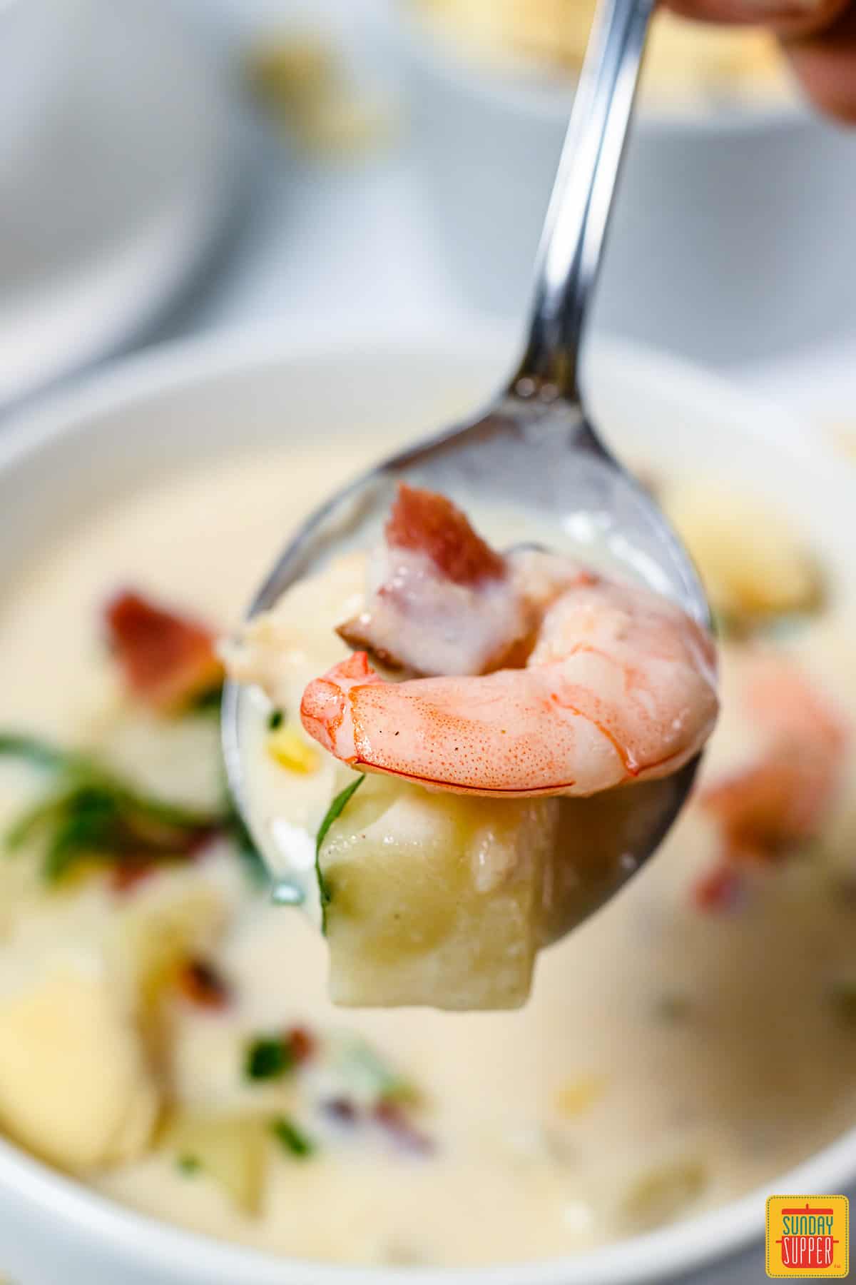 A spoonful of seafood chowder with shrimp