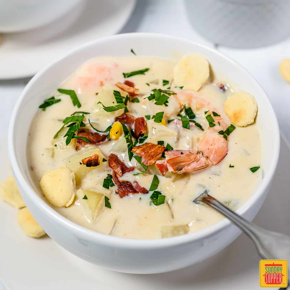 Seafood chowder in a white bowl with a spoon