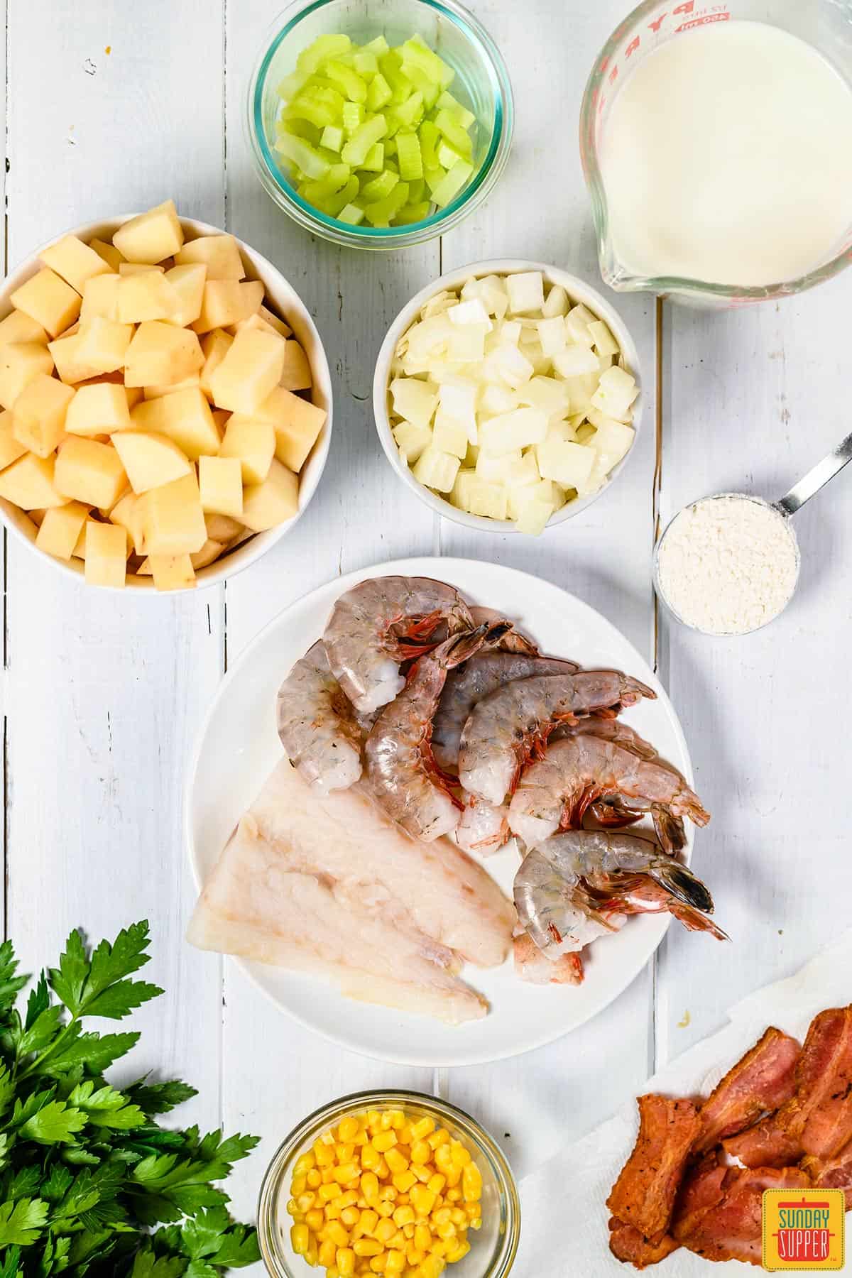 ingredients for seafood chowder on a white table