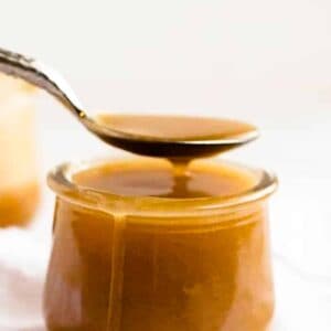 Butterscotch sauce with a spoon over a cup