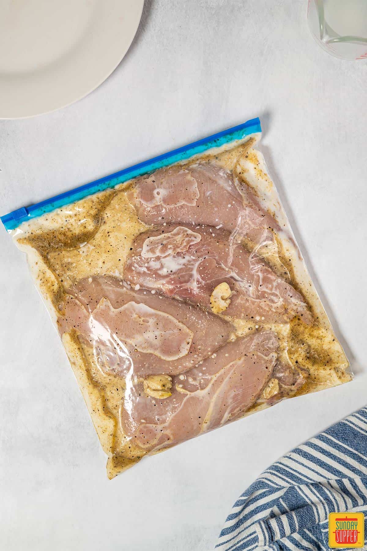 Chicken marinating in a plastic bag