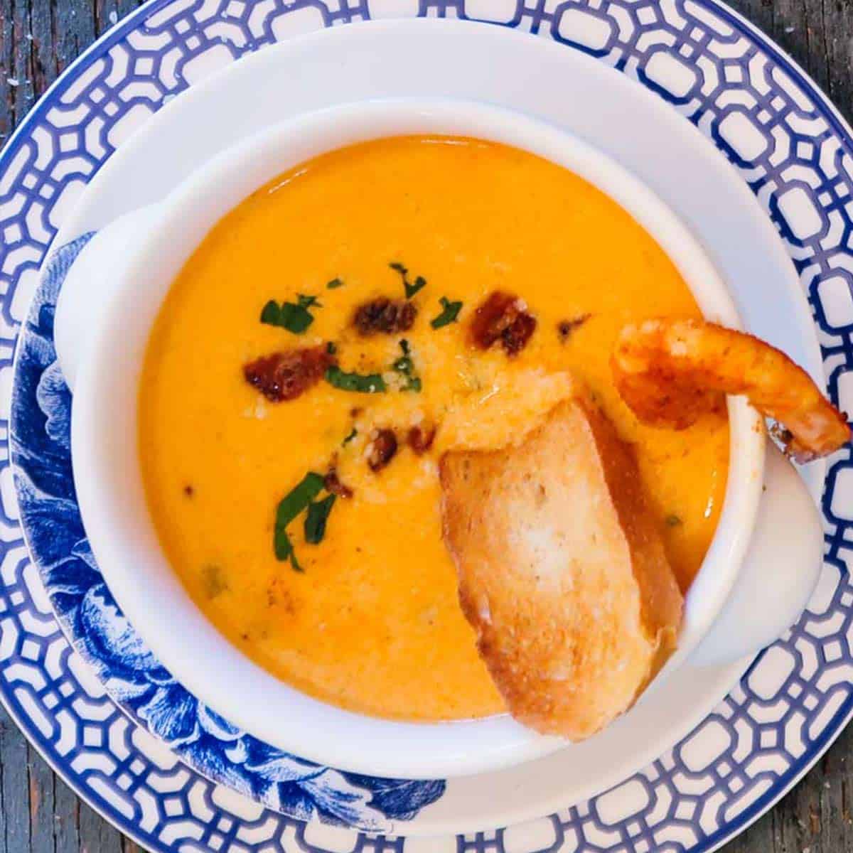 Shrimp bisque recipe in a white bowl on blue and white plates