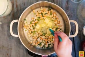 Adding butter to shrimp bisque recipe in pot