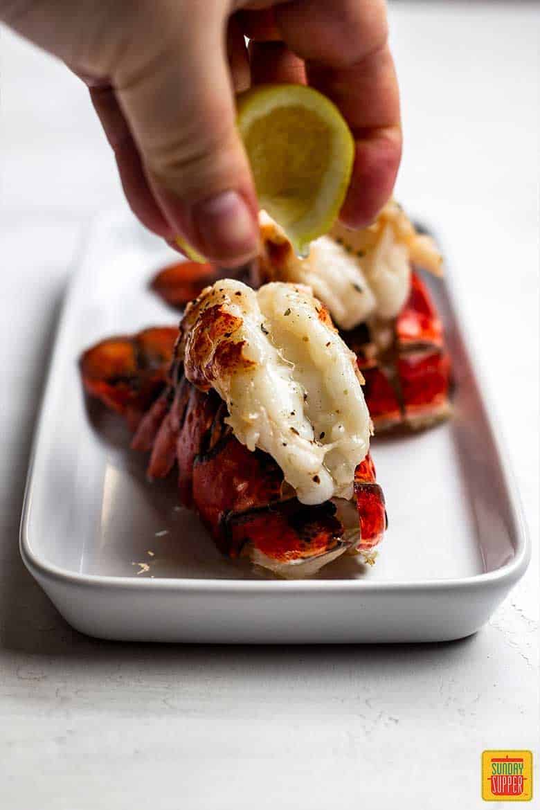 Squeezing lemon onto an air fryer fried lobster tail