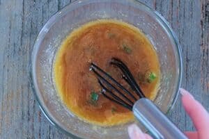 Mixing honey ham glaze together with whisk in a glass bowl