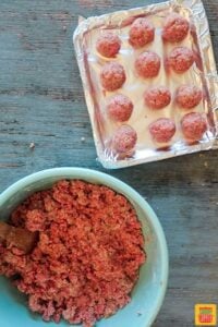 Raw meatballs on an air fryer tray