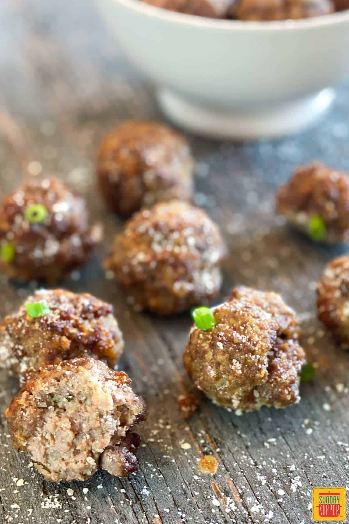 Air fryer meatballs on the table in front of a bowl