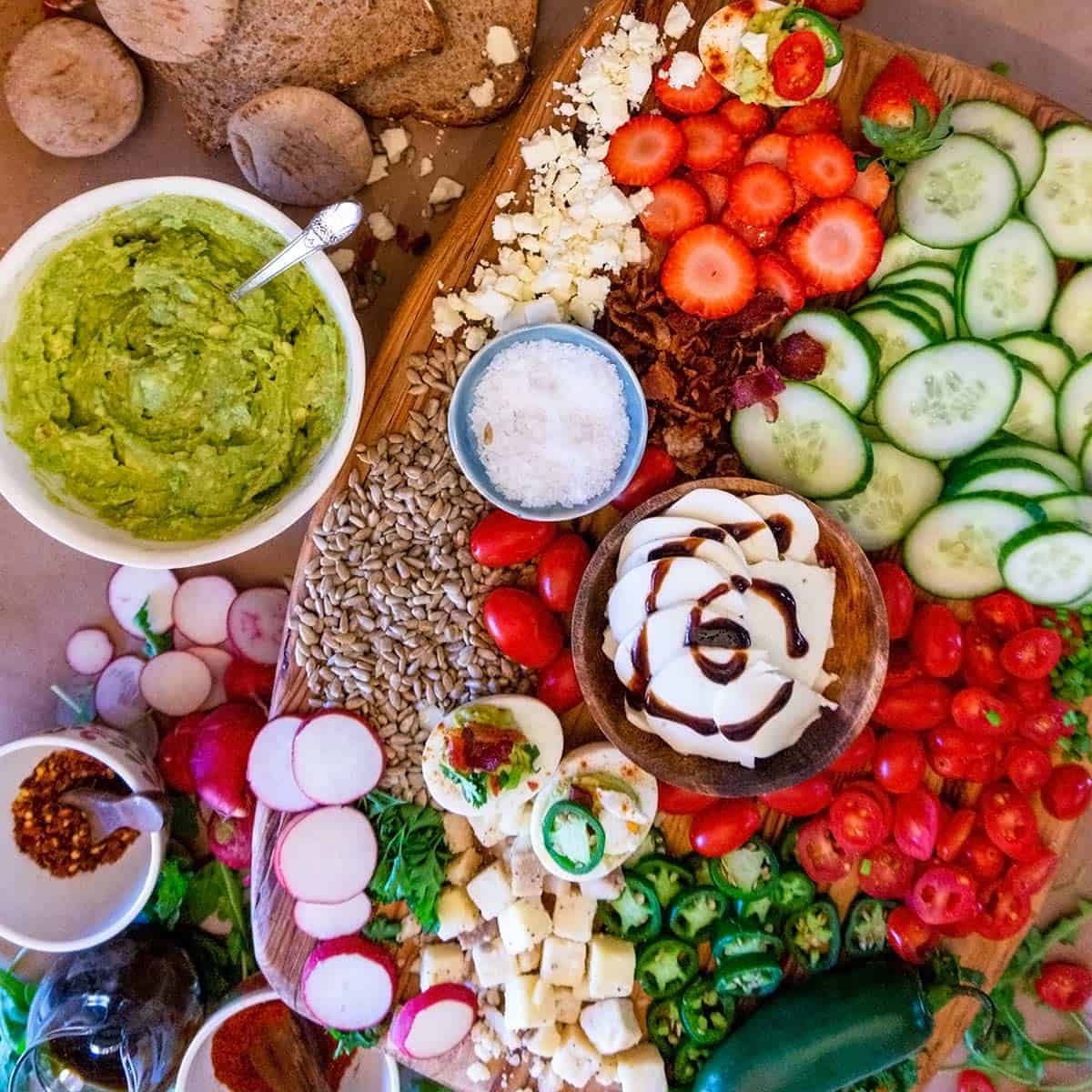Avocado toast toppings bar with a platter of toppings and avocado spread