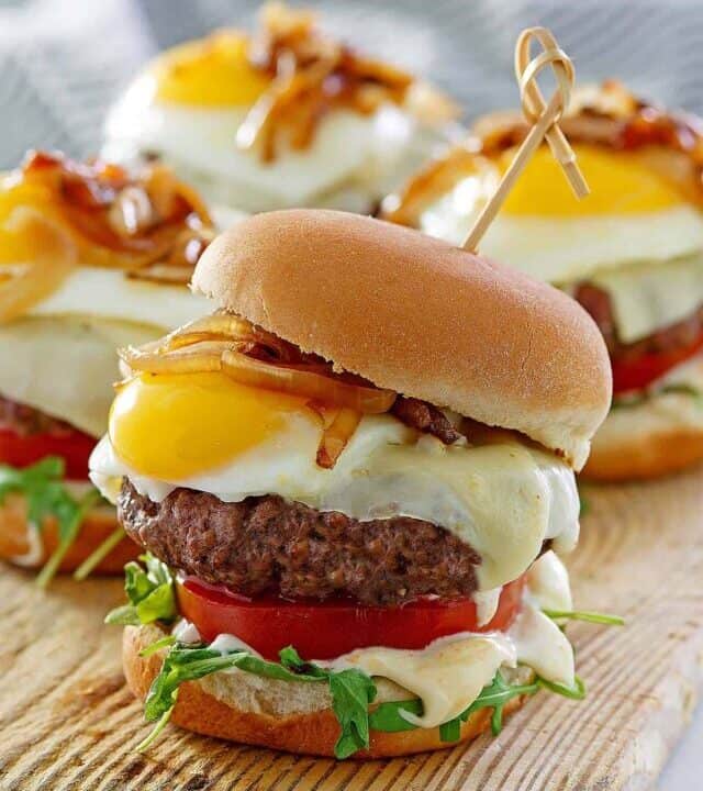 egg burger on a board with three other burgers
