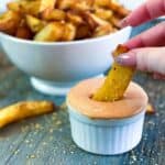 Dipping a fry into fry sauce recipe in a white bowl