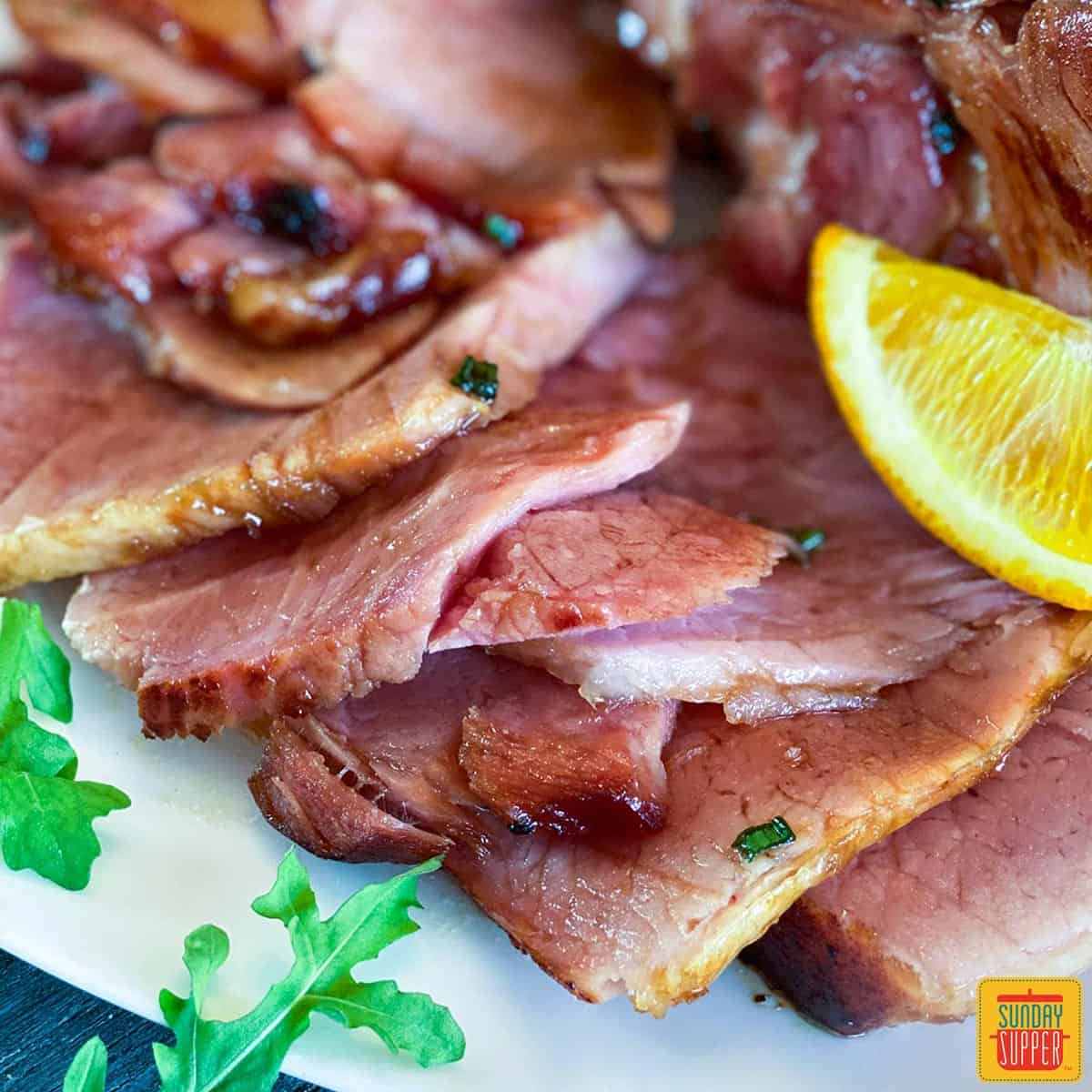 Sliced ham with oranges and arugula