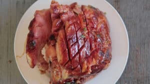 Slicing and adding glaze to Instant Pot Ham on white platter