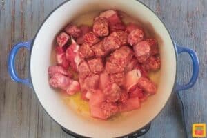 Adding meat to meatball sauce recipe in pan
