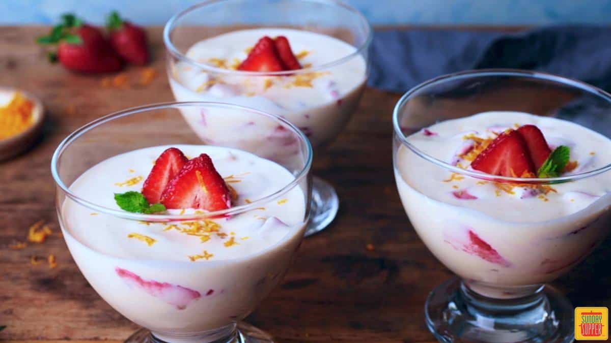 Three bowls of fresh strawberries and cream