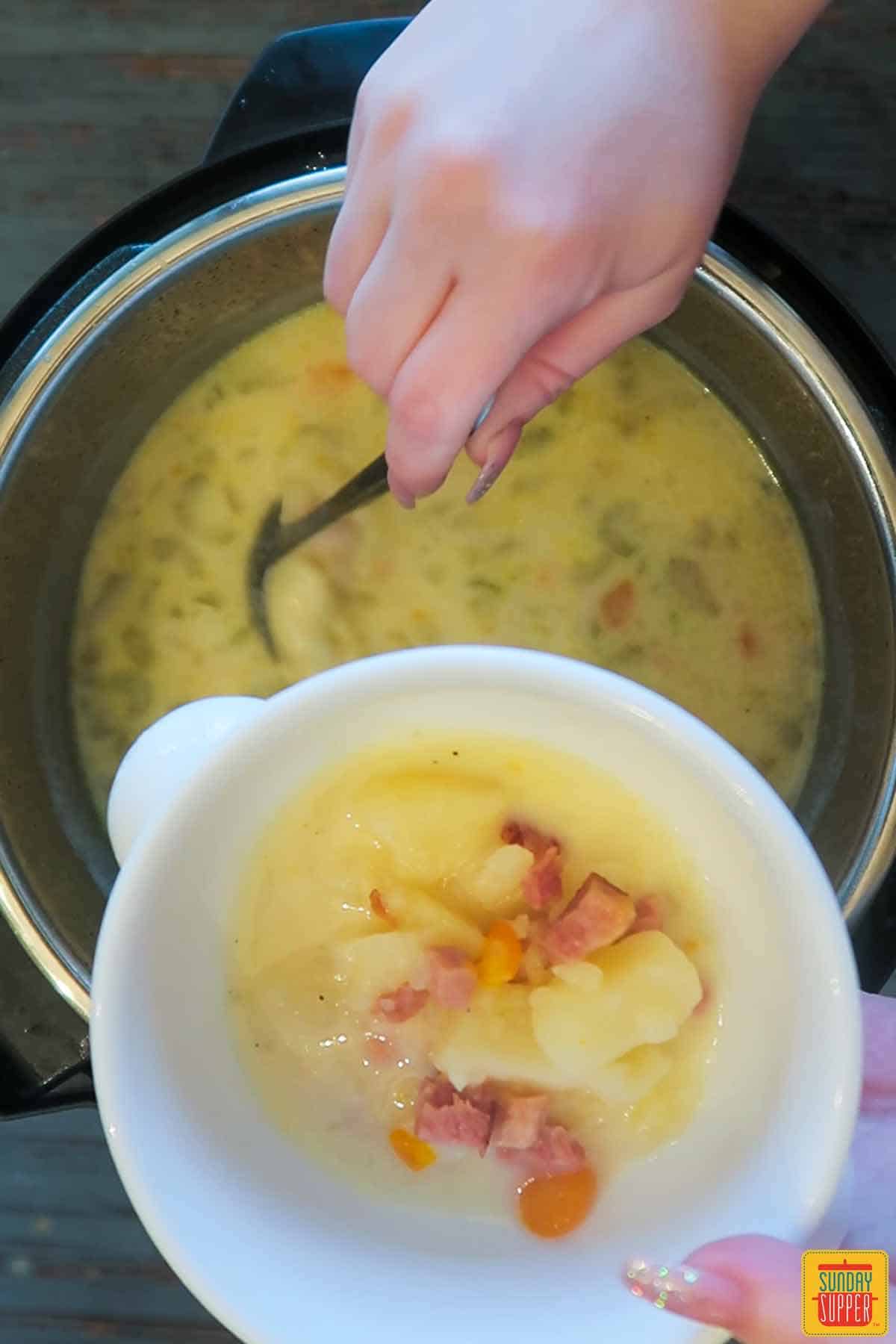 Ladling instant pot ham soup into a bowl