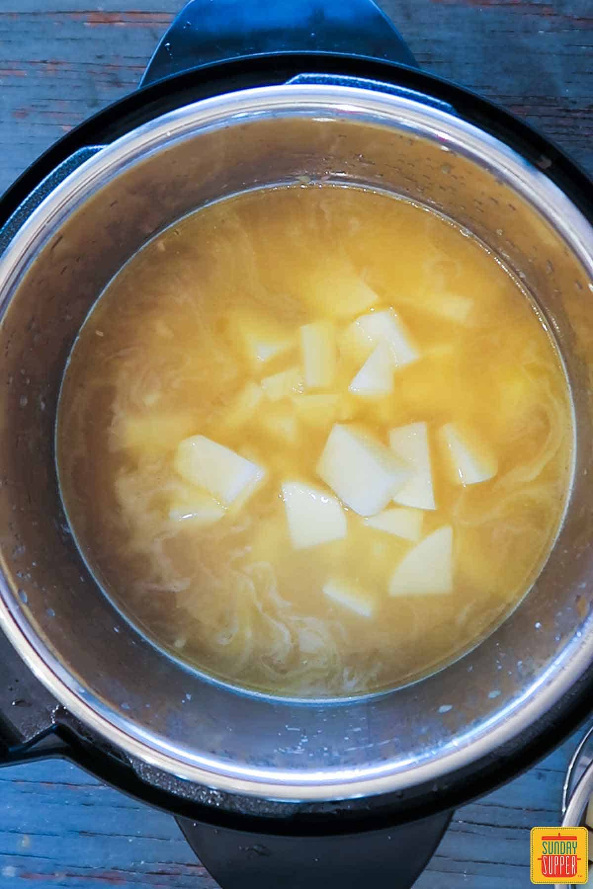 Adding potatoes to broth for ham soup recipe