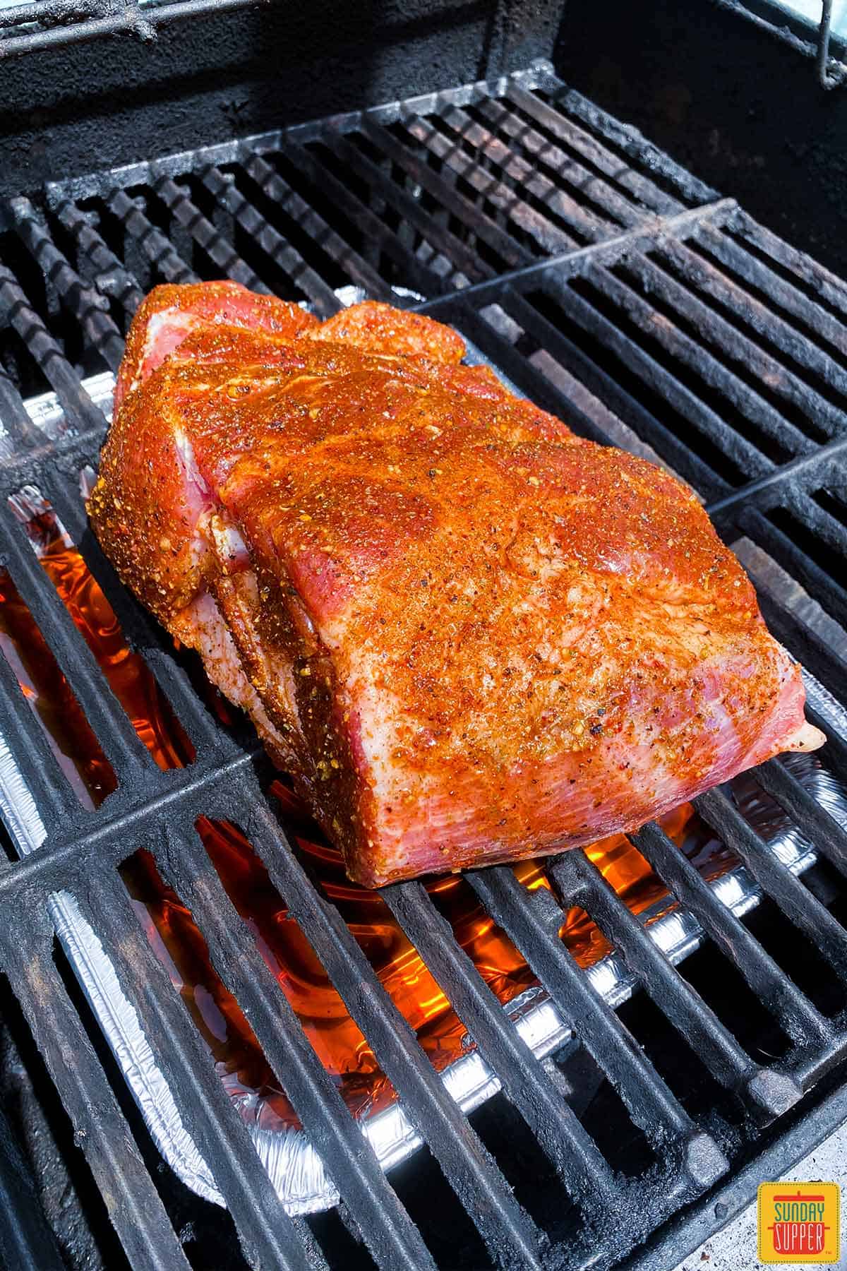 Pork butt on the grill getting ready to make grilled pork butt recipe