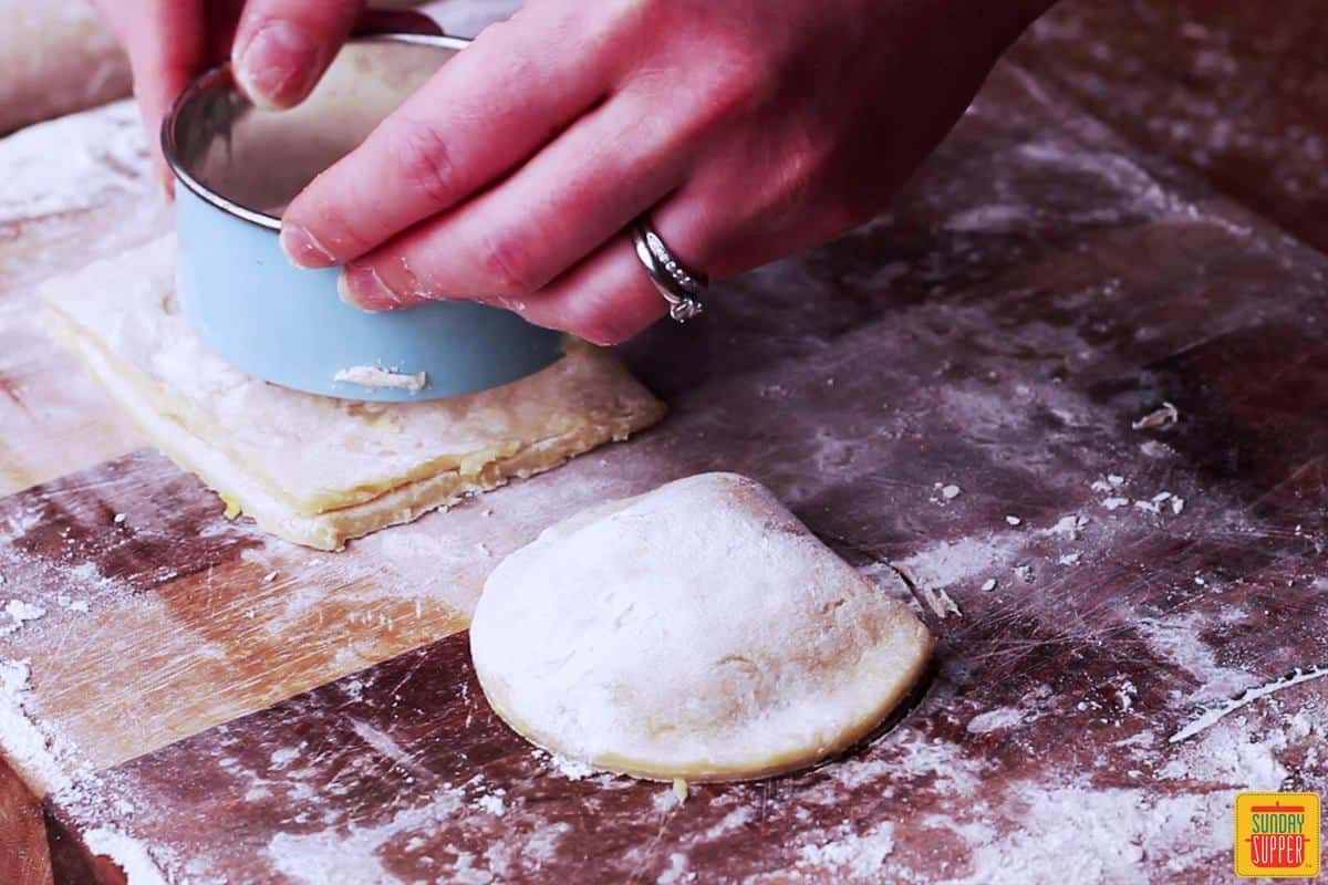 Cutting the Portuguese shrimp empanadas into half-moons with a cookie cutter