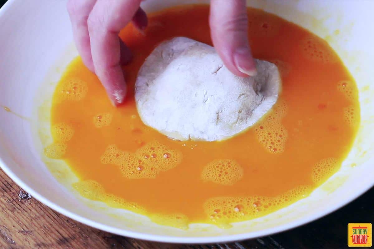 Coating Portuguese shrimp dumplings in egg
