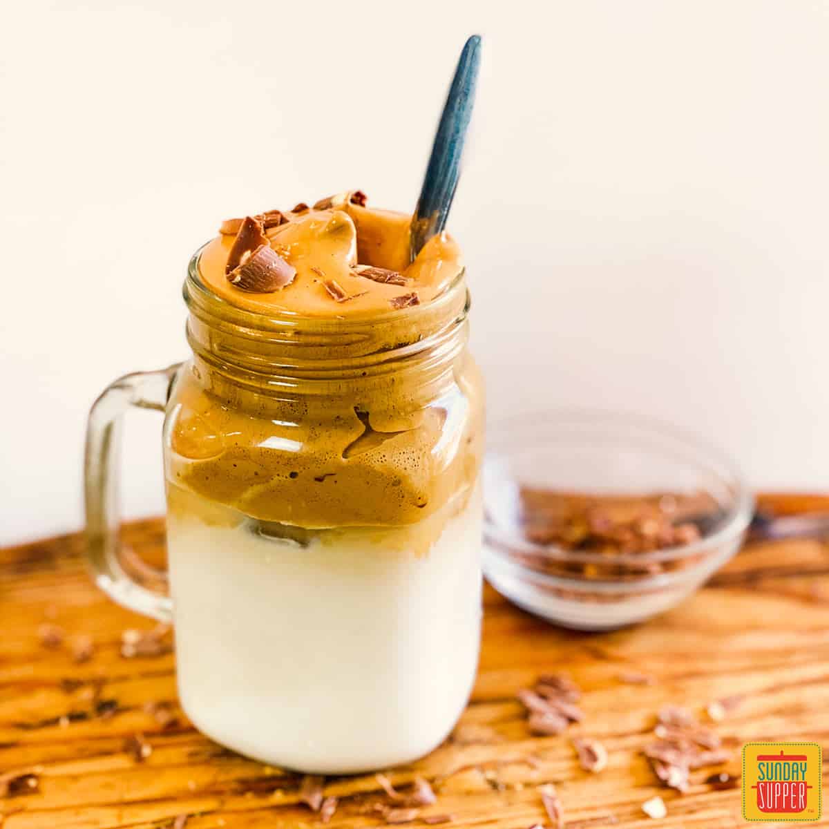 Whipped coffee in a glass jar on a cutting board