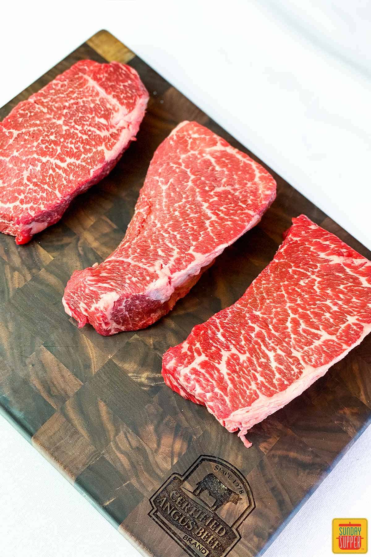 Uncooked beef short ribs on a cutting board with beautiful marbling