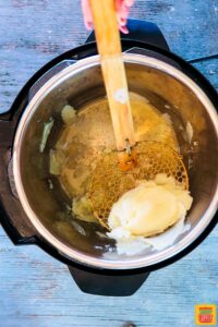 Spooning out the instant pot potatoes with a strainer spoon