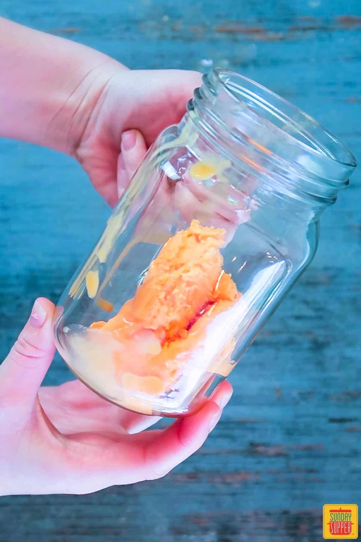 Scoops of sherbet in a glass jar to make momosa mimosa recipe