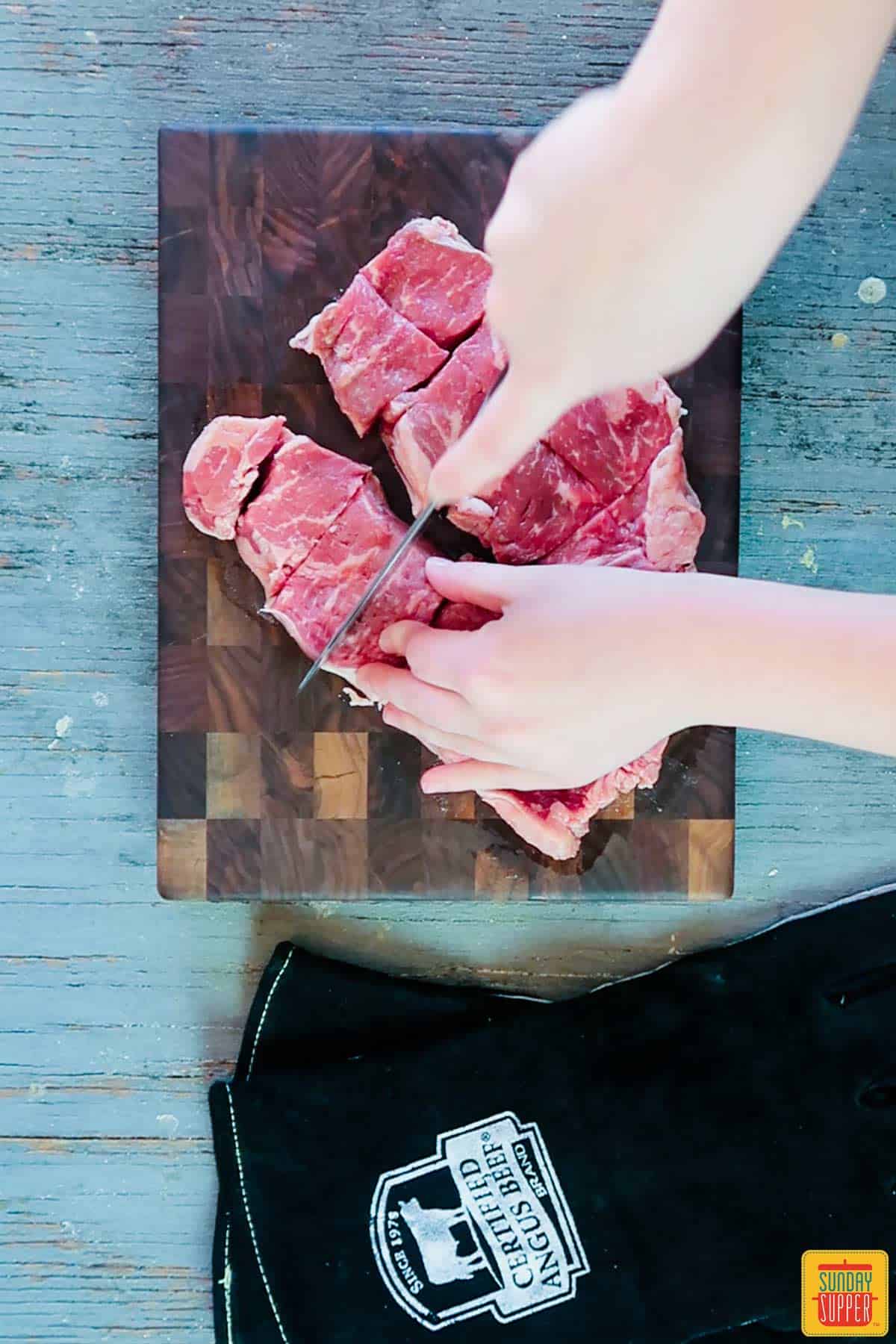 Cutting Certified Angus Beef® brand strip steaks into cubes for Portuguese Beef Skewers (Espetada Madeira)
