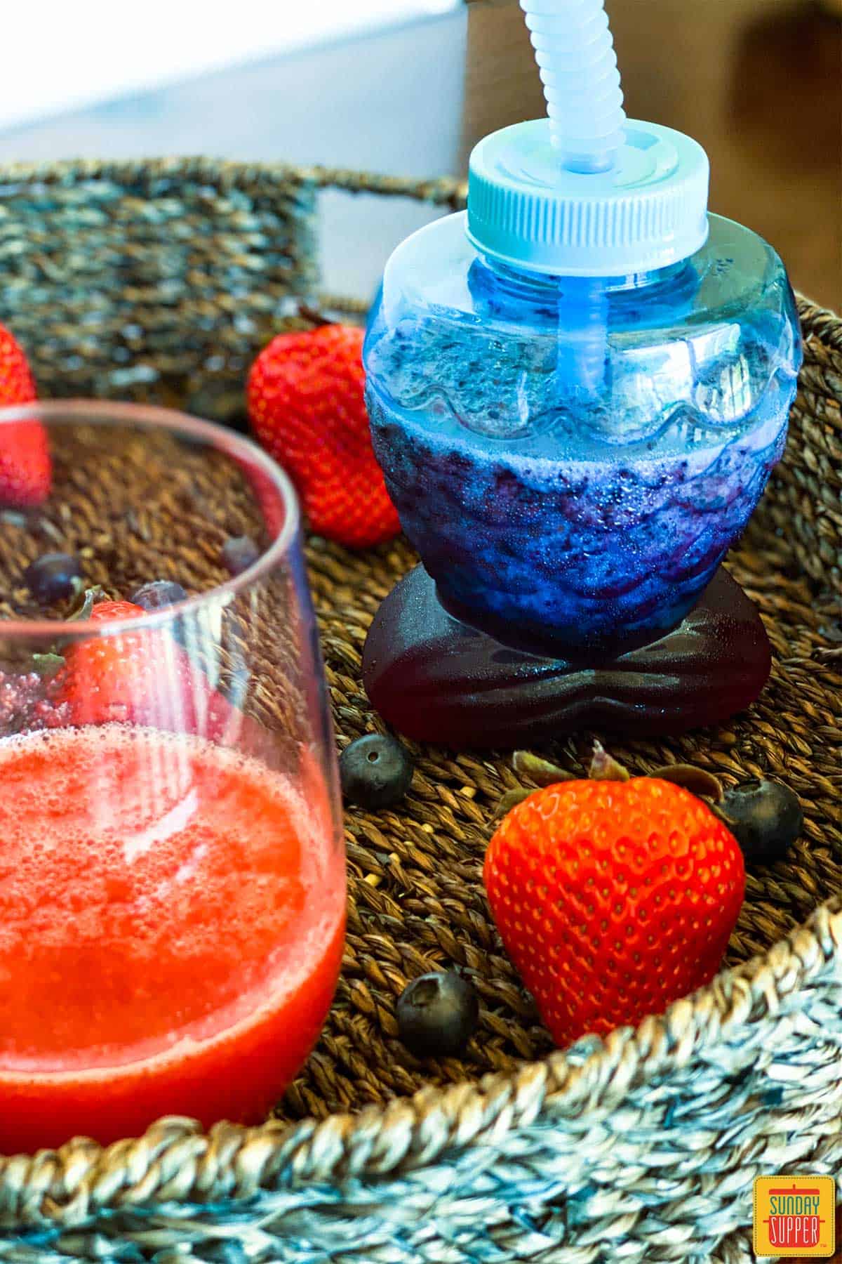 Close up photo of frozen strawberry daiquiri recipe with non-alcoholic version in a cute blue fish-shaped cup with a bendy straw