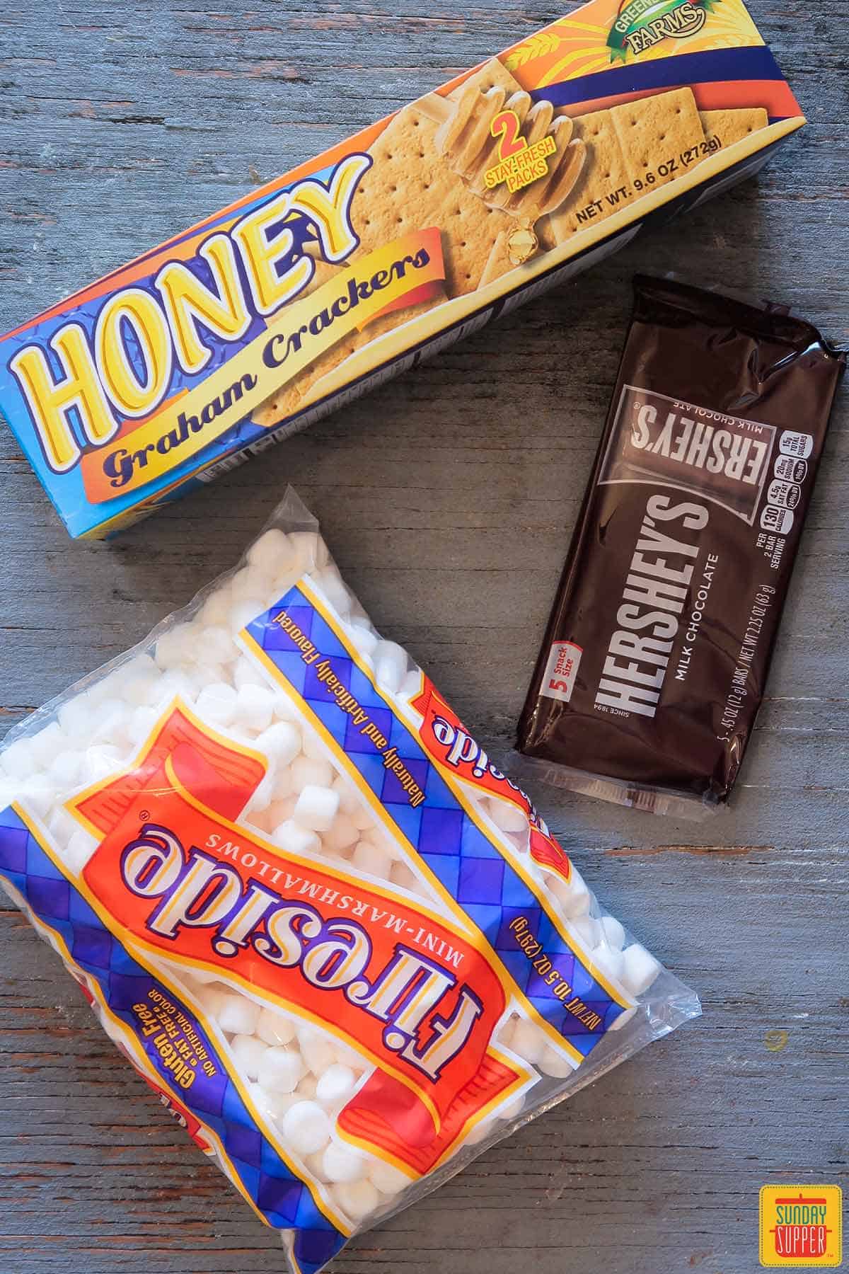 Ingredients to make s'mores: honey graham crackers, mini marshmallows, and a chocolate bar