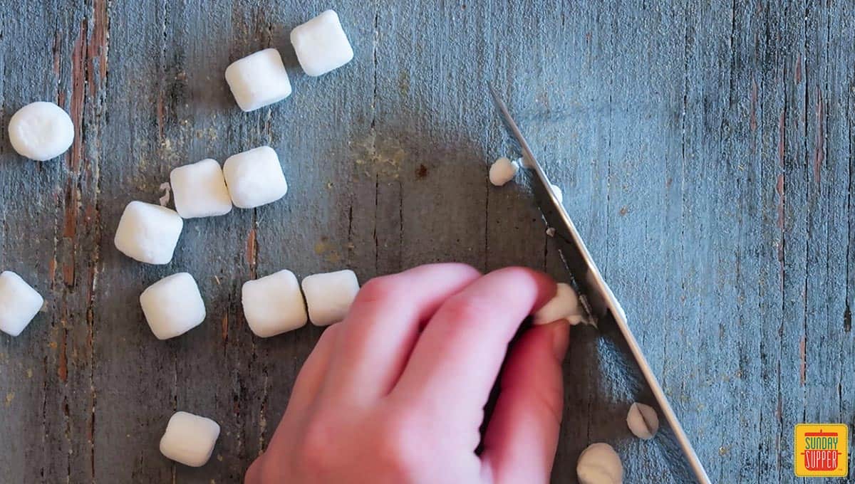 Cutting mini marshmallows in half with a sharp knife