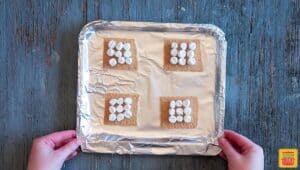Marshmallows on graham crackers on the air fryer tray wrapped in aluminum foil to make air fryer s'mores recipe