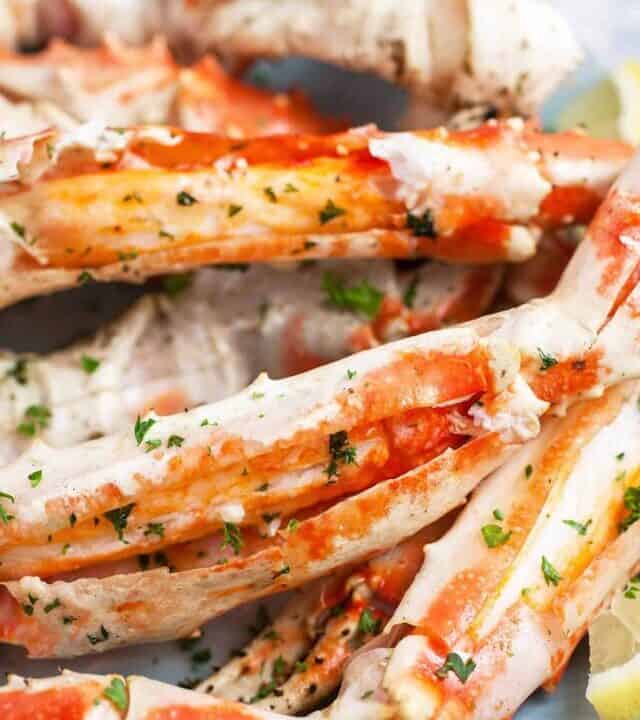 Grilled Crab legs with lemon wedges and garlic butter sauce.