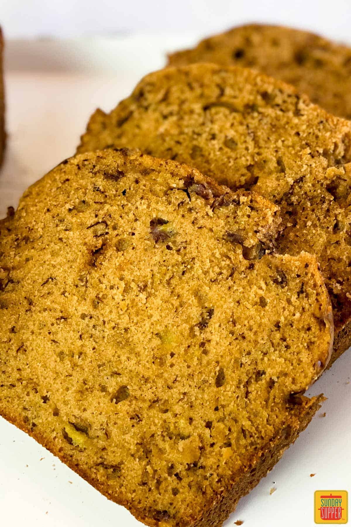 Close up of three slices of Instant Pot Banana bread on a white surface