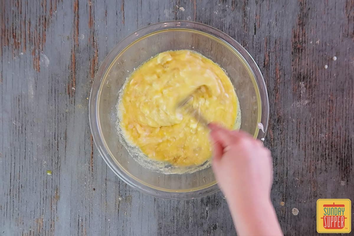 Mixing the bananas with the egg mixture and sour cream in a bowl