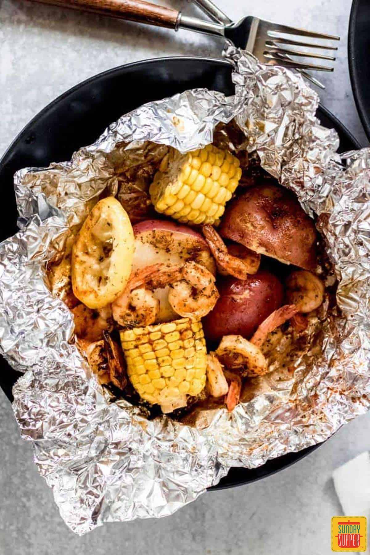 Shrimp, corn, and potatoes in a foil packet after cooking