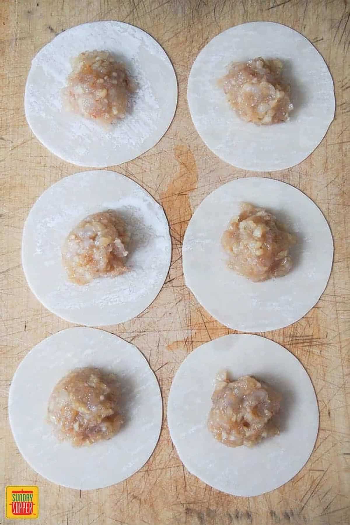 putting filling for shrimp shumai in dumpling wrappers