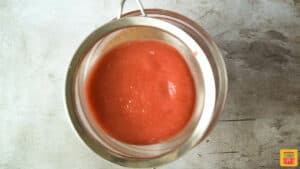 straining strawberry sauce