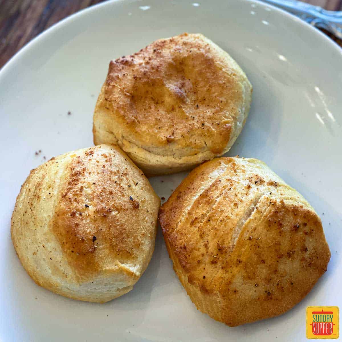 Close up of three air fryer biscuits on a white plate