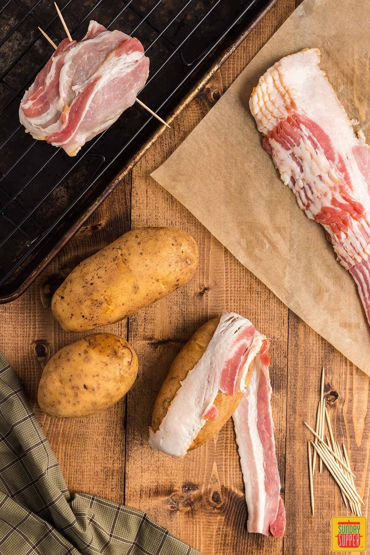 Wrapping a russet potato with bacon slices