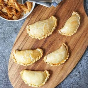 baked empanadas on a wood board