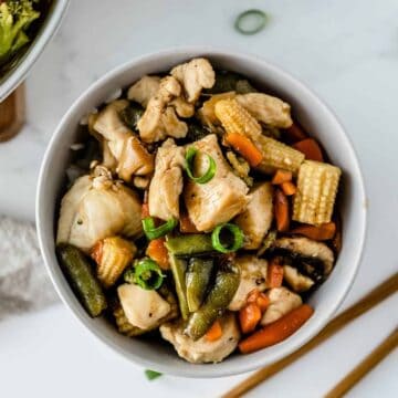 Easy 5-ingredient chicken stir fry in a white bowl with chopsticks to the side