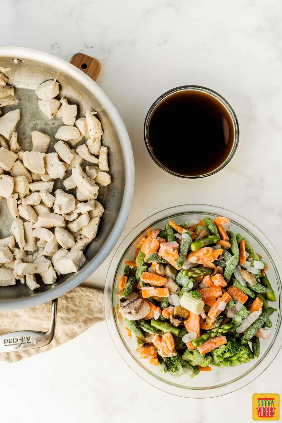 Ingredients to make 5-ingredient chicken stir-fry: chicken breast, teriyaki sauce, and frozen vegetables