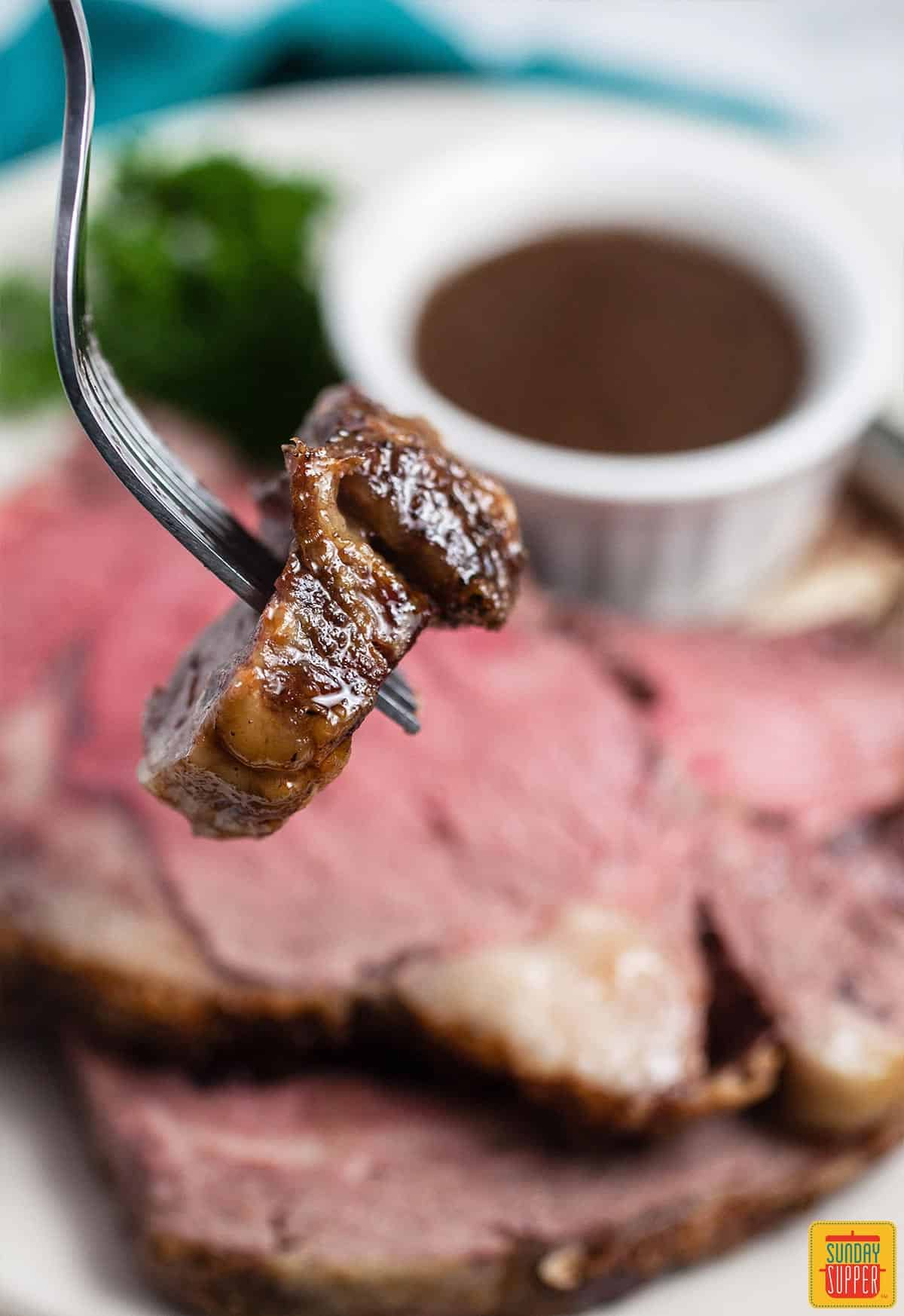 A fork with a bite of prime rib