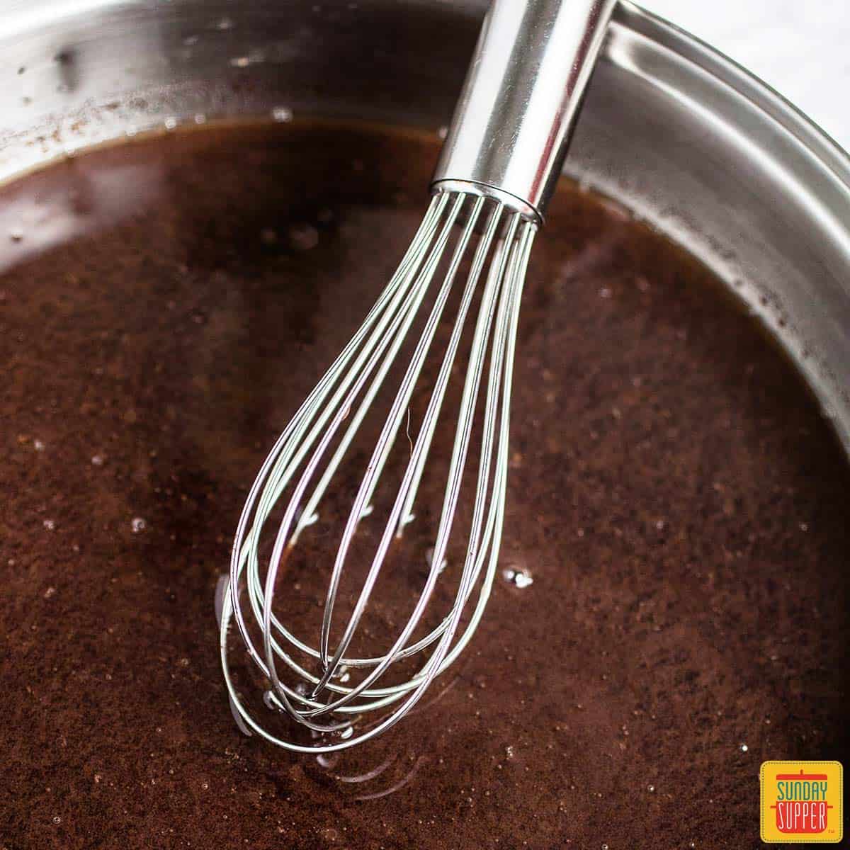 A whisk over a bowl of au jus
