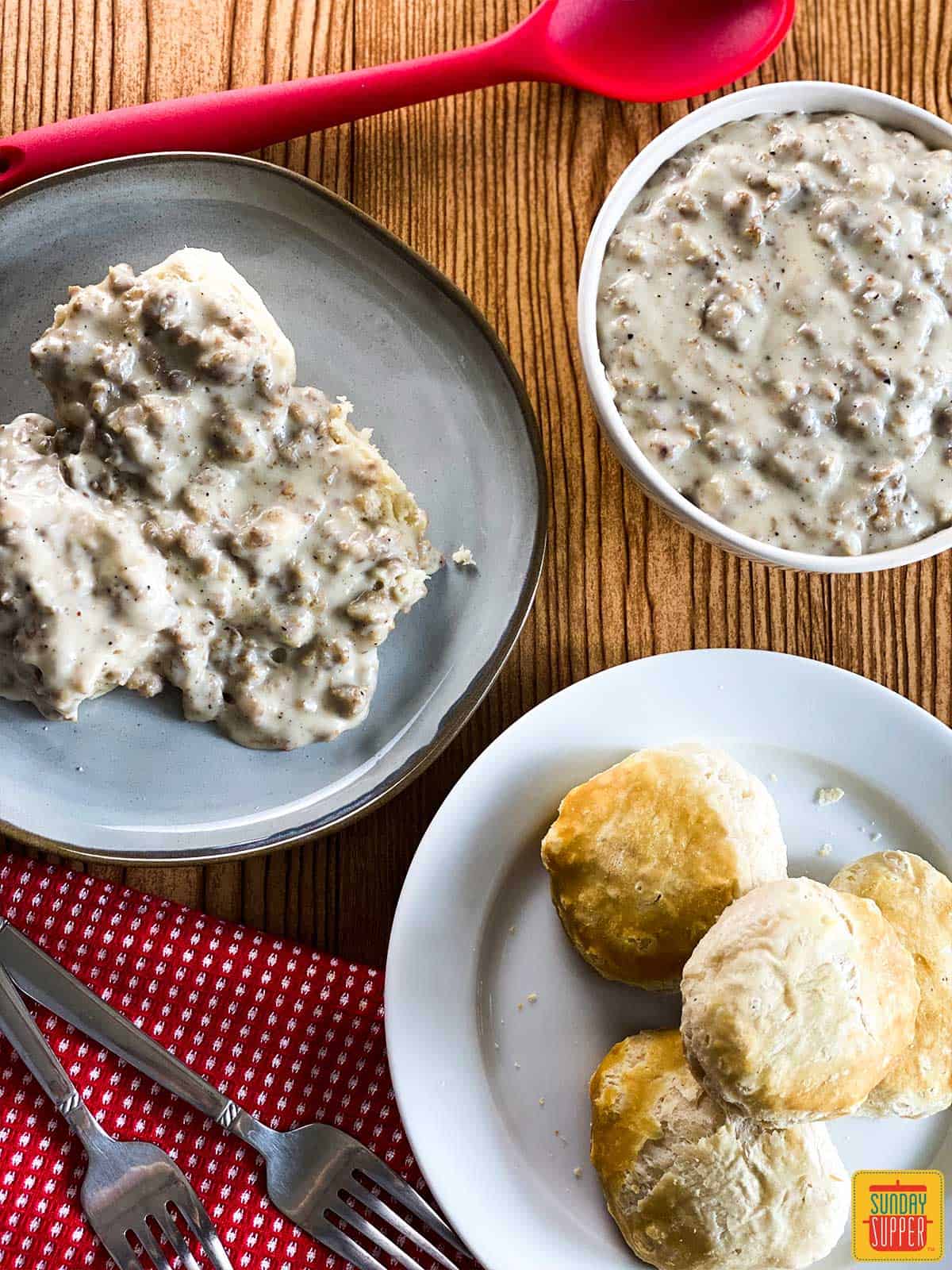 Instant pot sausage gravy in a bowl and on biscuits on a plate with plain biscuits on a plate next to it